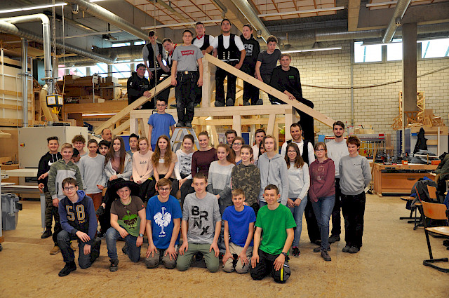 Zimmererazubis und Werkrealschüler freuen sich am aufgerichteten Gartenhaus